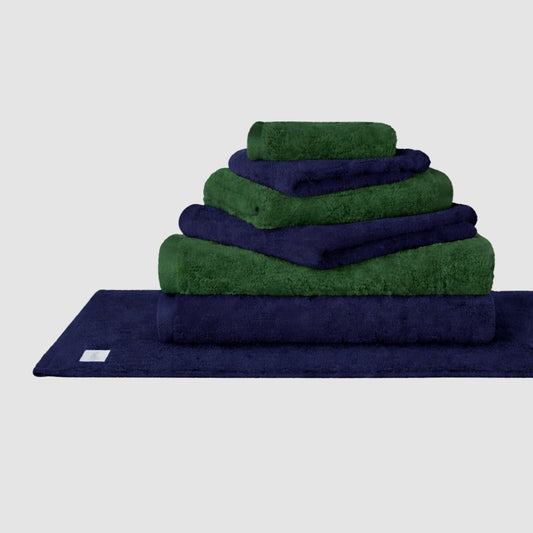 Gestapeltes Wabi Sabi Handtuch-Set in Navy und Grün von Momo Cotton auf neutralem Hintergrund