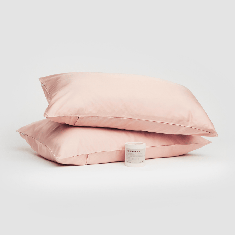 Paar rosa Baumwoll-Kissenbezüge mit Somnia 1.0 Produkt auf weißem Hintergrund