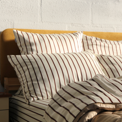 Bamboo striped sheet set with matching pillows on light wood bed frame