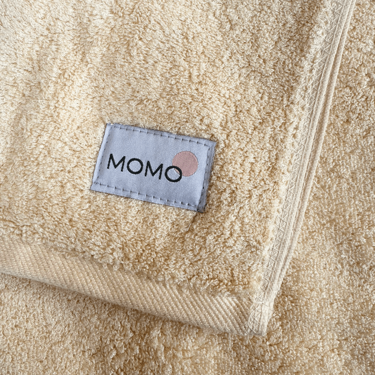 Beige Bambus-Handtuch mit Momo-Logo – weich, saugfähig und nachhaltig
